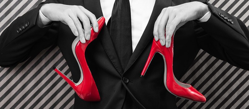 Image of smart man holding a pair of red heels